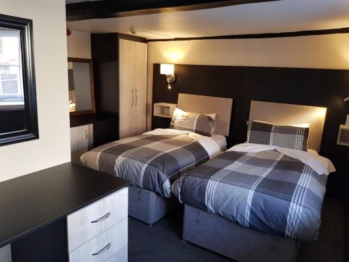a bedroom with two beds and a desk at The Old Black Horse Inn in Oxford