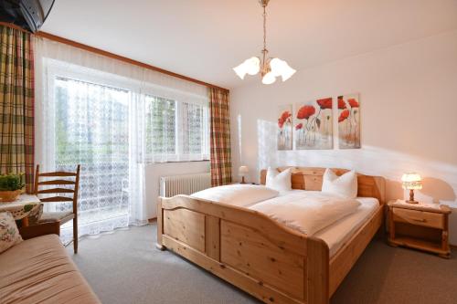 a bedroom with a large wooden bed and a window at das Christophorus in Söll