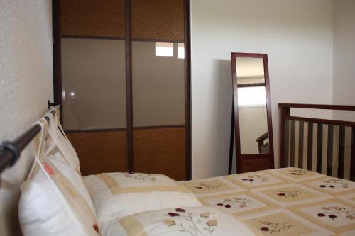 - une chambre avec un lit et un miroir dans l'établissement T2 duplex au 2éme étage sur le port ostreicole Andernos ,Bassin d'Arcachon, à Andernos-les-Bains