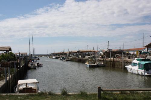 un groupe de bateaux est amarré dans un canal dans l'établissement T2 duplex au 2éme étage sur le port ostreicole Andernos ,Bassin d'Arcachon, à Andernos-les-Bains