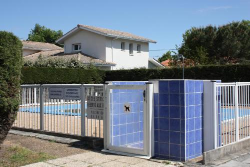 un portail en face d'une clôture avec une piscine dans l'établissement T2 duplex au 2éme étage sur le port ostreicole Andernos ,Bassin d'Arcachon, à Andernos-les-Bains