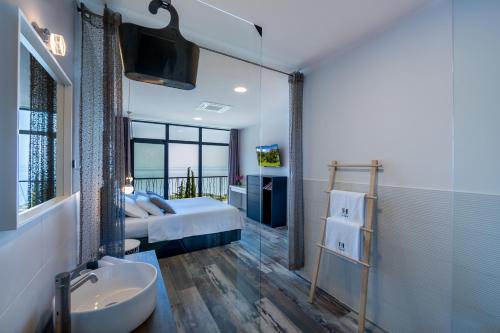 a bedroom with a bed and a bathroom with a sink at Villa The View Opatija in Opatija