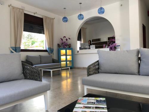 a living room with two couches and a mirror at Hotel Riviera in Alghero