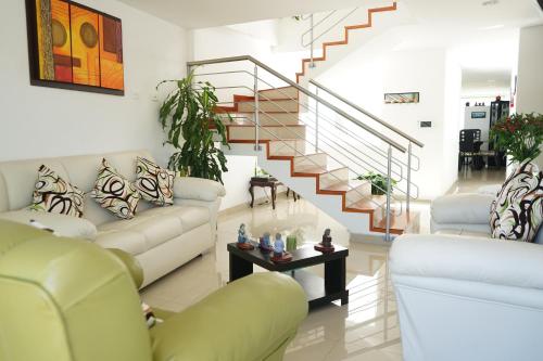 a living room with couches and a staircase at Posada Ventura in Duitama