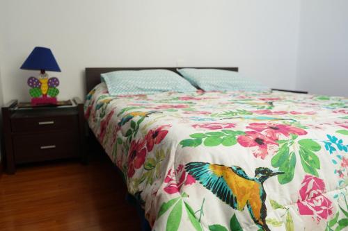 a bedroom with a bed with a colorful comforter at Posada Ventura in Duitama