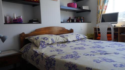 a bedroom with a bed with a blue and white comforter at Posada Ventura in Duitama