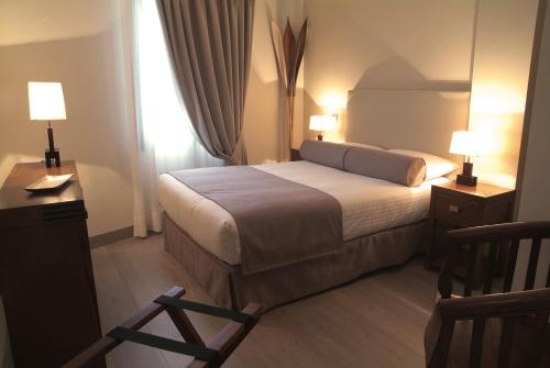 um quarto de hotel com uma cama e uma cadeira em Le Petit Boutique Hotel em Santander