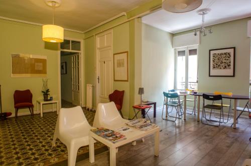 een woonkamer met stoelen en een tafel bij Pensión Blanca B&B in León