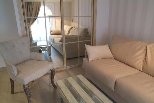 a living room with a couch and a chair and a mirror at Le Petit Boutique Hotel in Santander