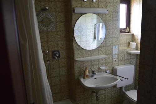 a bathroom with a sink and a mirror at Gästehaus Fäßle in Weinstadt