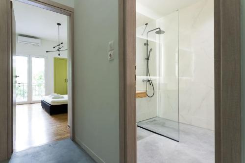 La salle de bains est pourvue d'une douche avec une porte en verre. dans l'établissement Luxurious Family Home in the Heart of Athens, à Athènes