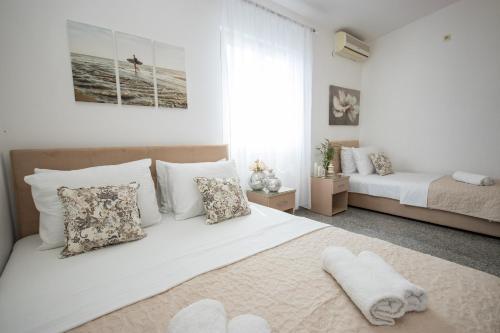 biała sypialnia z łóżkiem i 2 łóżkami w obiekcie Villa Kovacevic w Barze