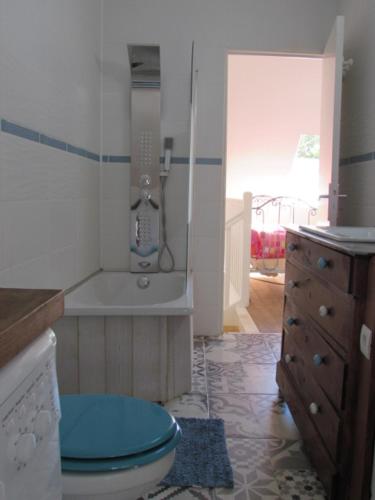 y baño con aseo azul y lavamanos. en Fisherman's cottage, en Ile d'Arz