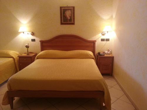 a hotel room with a bed and two night stands at Hotel Mistef in Falerna