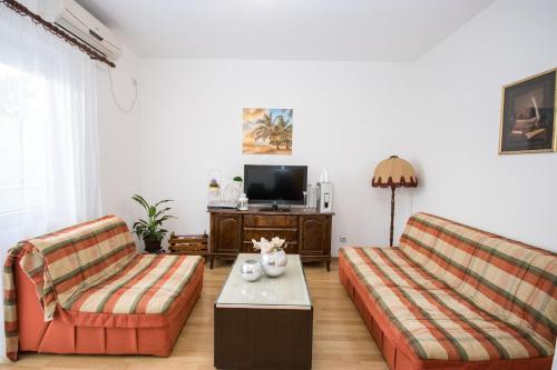 a living room with two couches and a tv at Villa Kovacevic in Bar