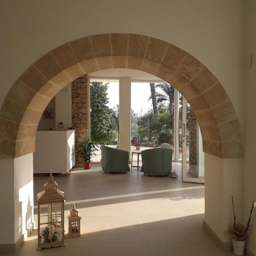 an archway in a room with chairs and a table at Villa Minerva Family Relais in Alezio