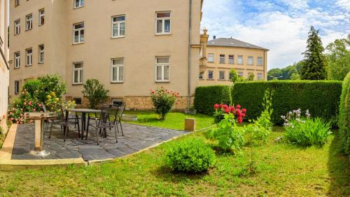 a garden with a table and chairs in front of a building at Ferienwohnungen Ender in Sebnitz