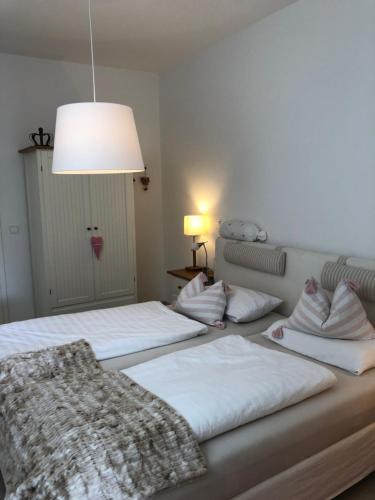 two beds in a room with a light fixture at Ferienwohnung Burgenblick mit Blick auf Riedenburg in Riedenburg