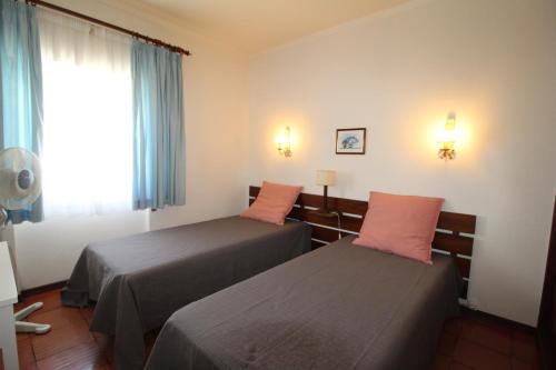 um quarto de hotel com duas camas e uma janela em ApartamentoSolPraia - BeloHorizonte em Portimão