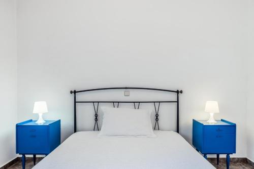 a bedroom with two blue night stands and a bed at Avgoustis' stone house in Otziás