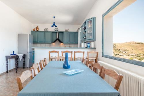uma sala de jantar com uma mesa azul e cadeiras em Avgoustis' stone house em Otziás
