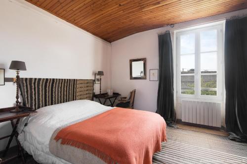 ein Schlafzimmer mit einem Bett und einem großen Fenster in der Unterkunft Le Clos du Vieux Porche in La Couarde-sur-Mer