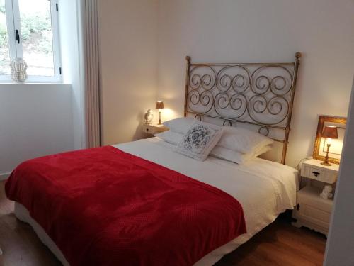 a bedroom with a large bed with a red blanket at Red House By The River in Porto