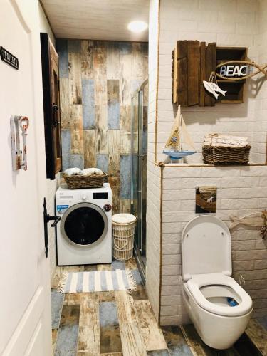 a bathroom with a washing machine and a toilet at Arapya Beach Apartment in Tsarevo