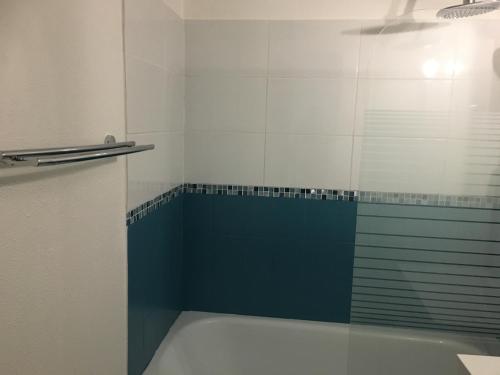 a bathroom with a tub and a glass shower door at Appartement vue mer in Villers-sur-Mer