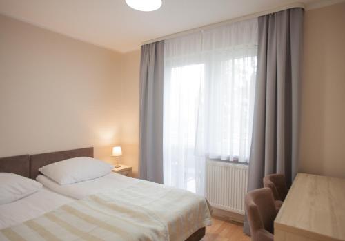 a bedroom with a bed and a large window at Angela Domki i Pokoje in Pobierowo