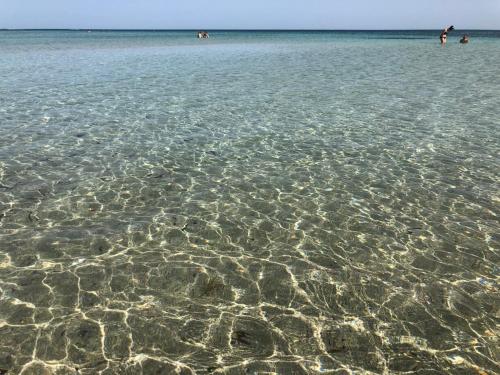 a large body of water with people swimming in it at Apulia Tourist Salento in Gemini