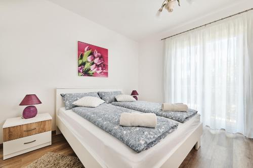 ein weißes Schlafzimmer mit einem großen Bett und einem Fenster in der Unterkunft Apartment Ana in Brtonigla