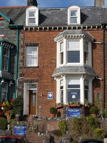 a brick house with signs in front of it at Swiss Court Guest House in Keswick