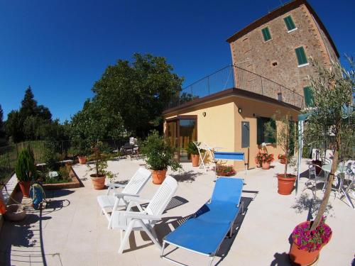a group of chairs and lounge chairs in front of a building at Saturnia Residence in Poggio Murella