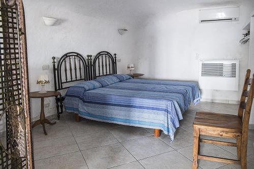 a bedroom with a bed with a blue striped blanket at Renato Canalone in Ponza