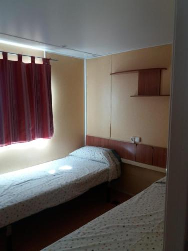 a small room with two beds and a window at La Masia in Sant Pere Pescador