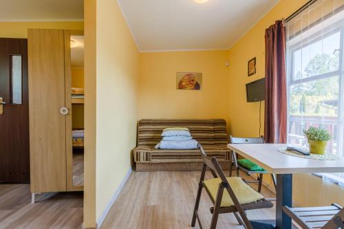 una stanza con un letto, un tavolo e delle sedie di ZAKĄTEK ADELI a Mikoszewo