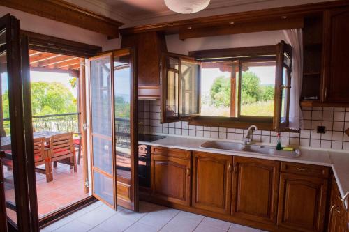 a kitchen with a sink and a view of a patio at Villa Anna in Nea Skioni