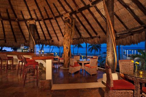 a restaurant with tables and chairs and a view of the ocean at Krystal Grand Los Cabos - All Inclusive in San José del Cabo