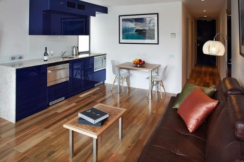 cocina y sala de estar con sofá y mesa en Salamanca Wharf Hotel, en Hobart