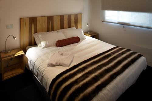 a bed with a white comforter and pillows at Salamanca Wharf Hotel in Hobart