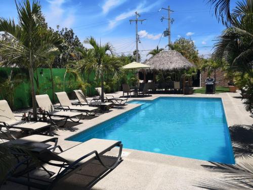 a swimming pool with chaise lounges and chairs around it at Studio Mauricio #5 in Bucerías