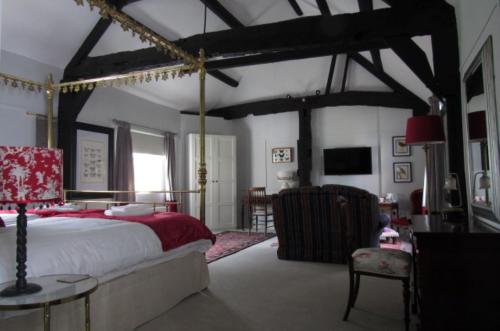 a bedroom with a large bed and a chair at The Old Vicarage Hotel & Restaurant in Bridgwater