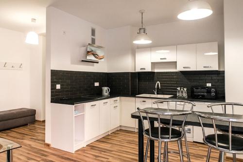 a kitchen with white cabinets and a table and chairs at Apartament na Wyspie Piasek in Kłodzko