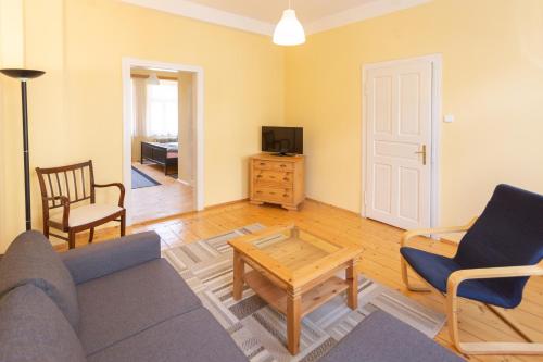a living room with a couch and chairs and a tv at Rodinný pension Bečov in Bečov nad Teplou