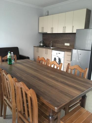kuchnia z długim drewnianym stołem i krzesłami w obiekcie Cottages Ureki w mieście Ureki