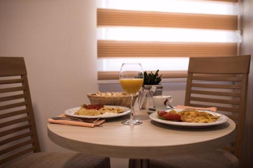 a table with two plates of food and a glass of wine at Apartmani MG in Trebinje