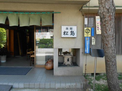 a building with a sign on the side of it at Ryokan Matsushima in Yokohama
