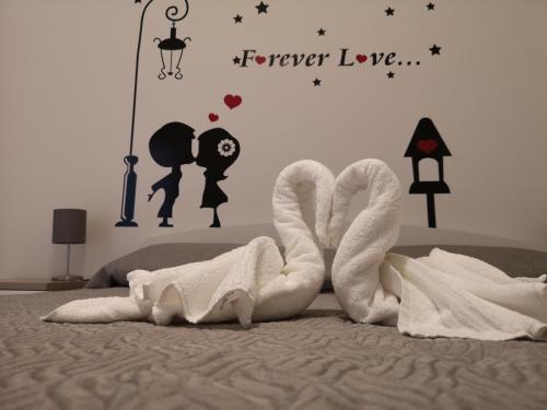 un letto con due asciugamani e un cartello che legge l'amore di mungiBEDdu Apartment a Catania