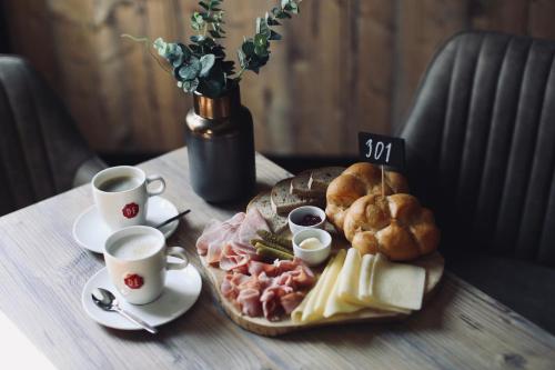 a plate of food on a table with two cups of coffee at Penzion U Kubesa - Adults only in Kroměříž